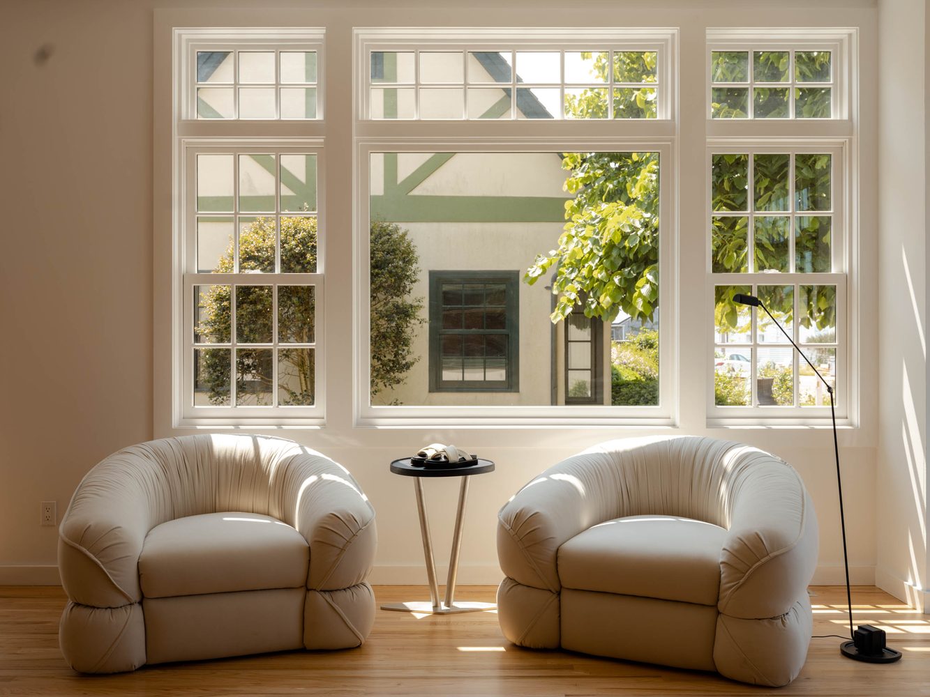 Two rounded armchairs before a garden window