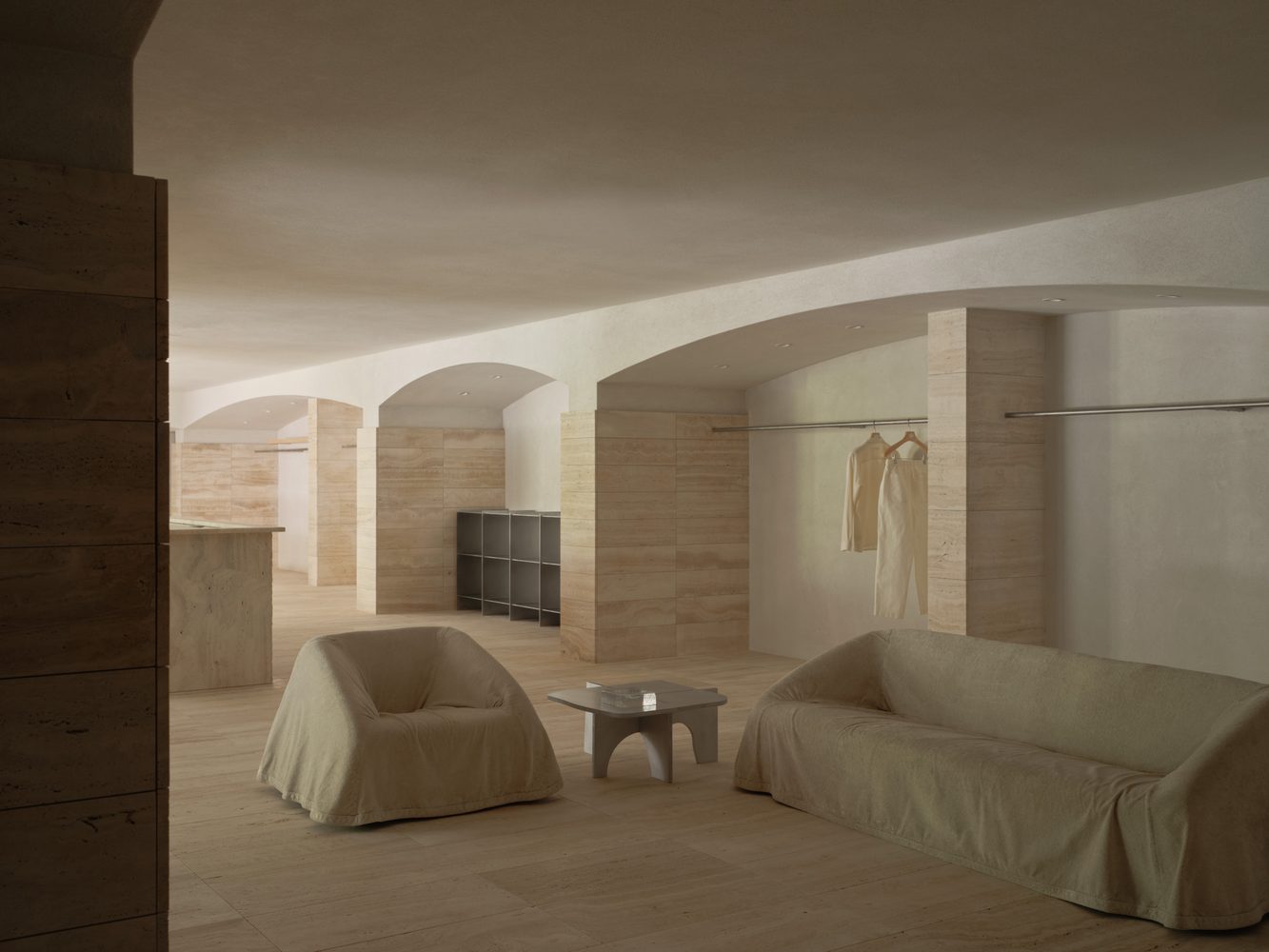 Travertine room with slipcovered armchairs