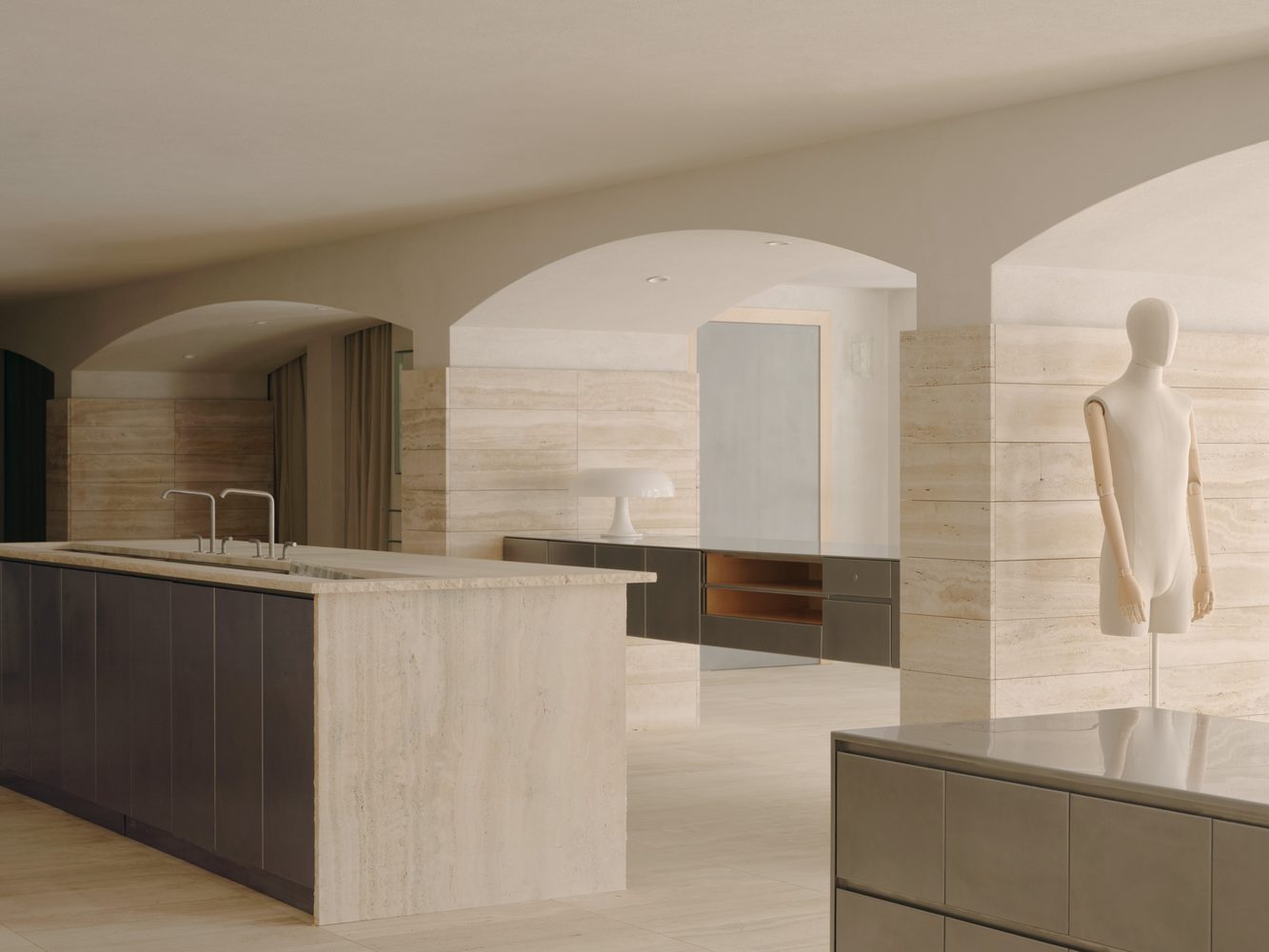 Travertine kitchen island framed by an arch