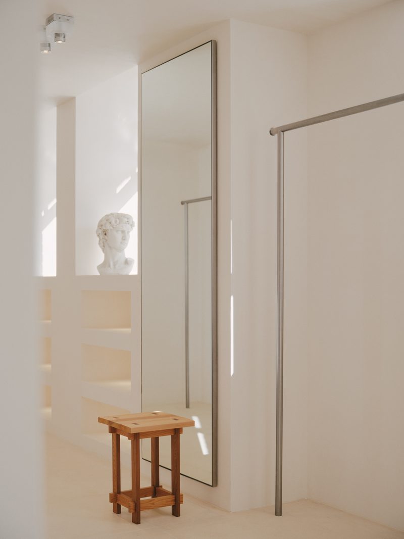 Tall mirror and steel rail in a white dressing room