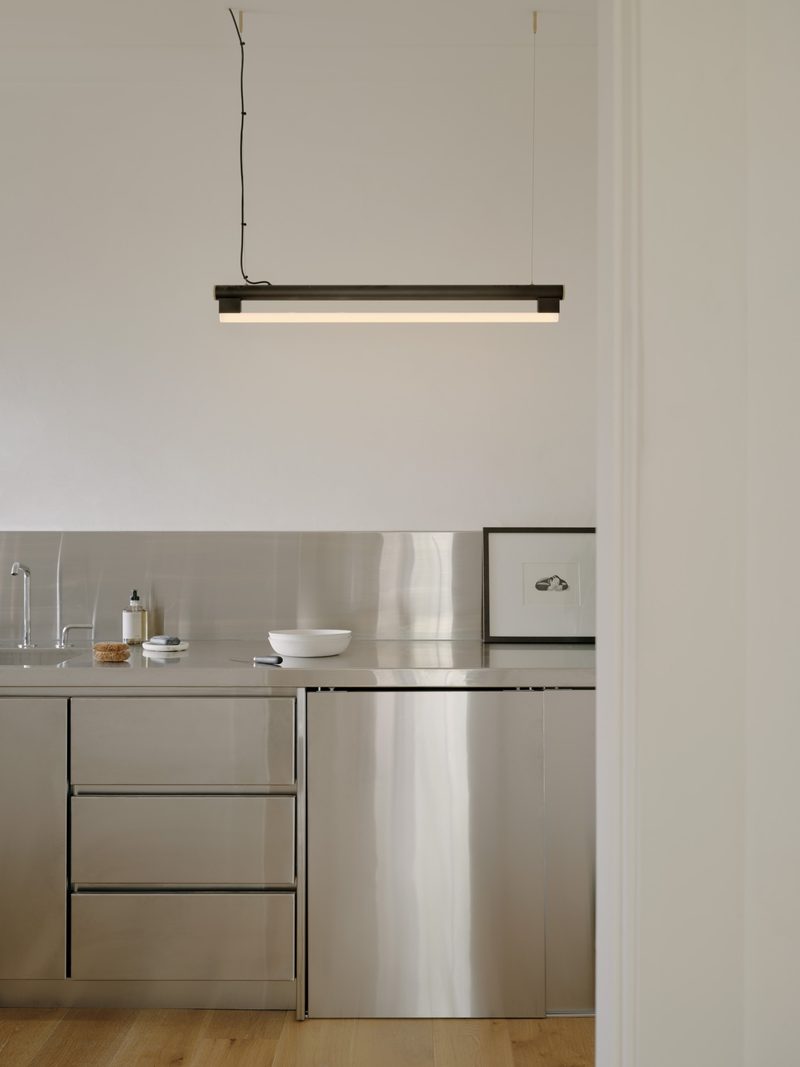 Stainless steel kitchen with a linear pendant light